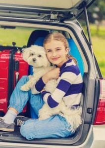 A girl traveling in a car with a dog