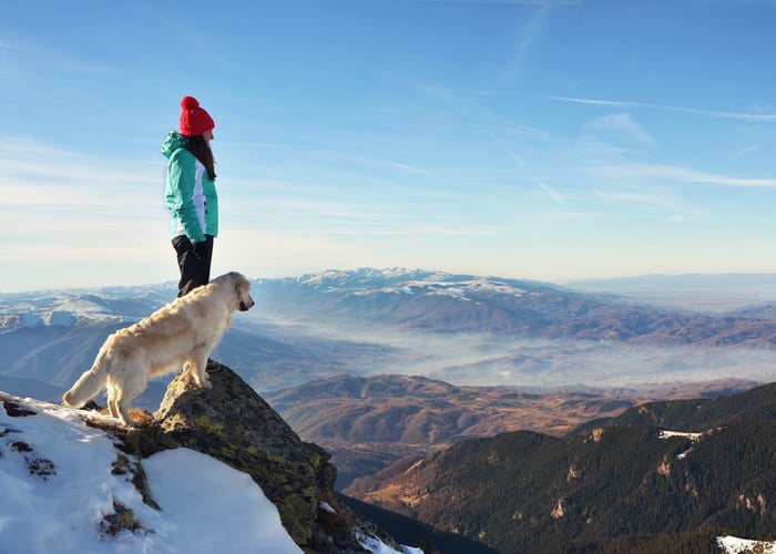 Dog and his owner in a snowy hike