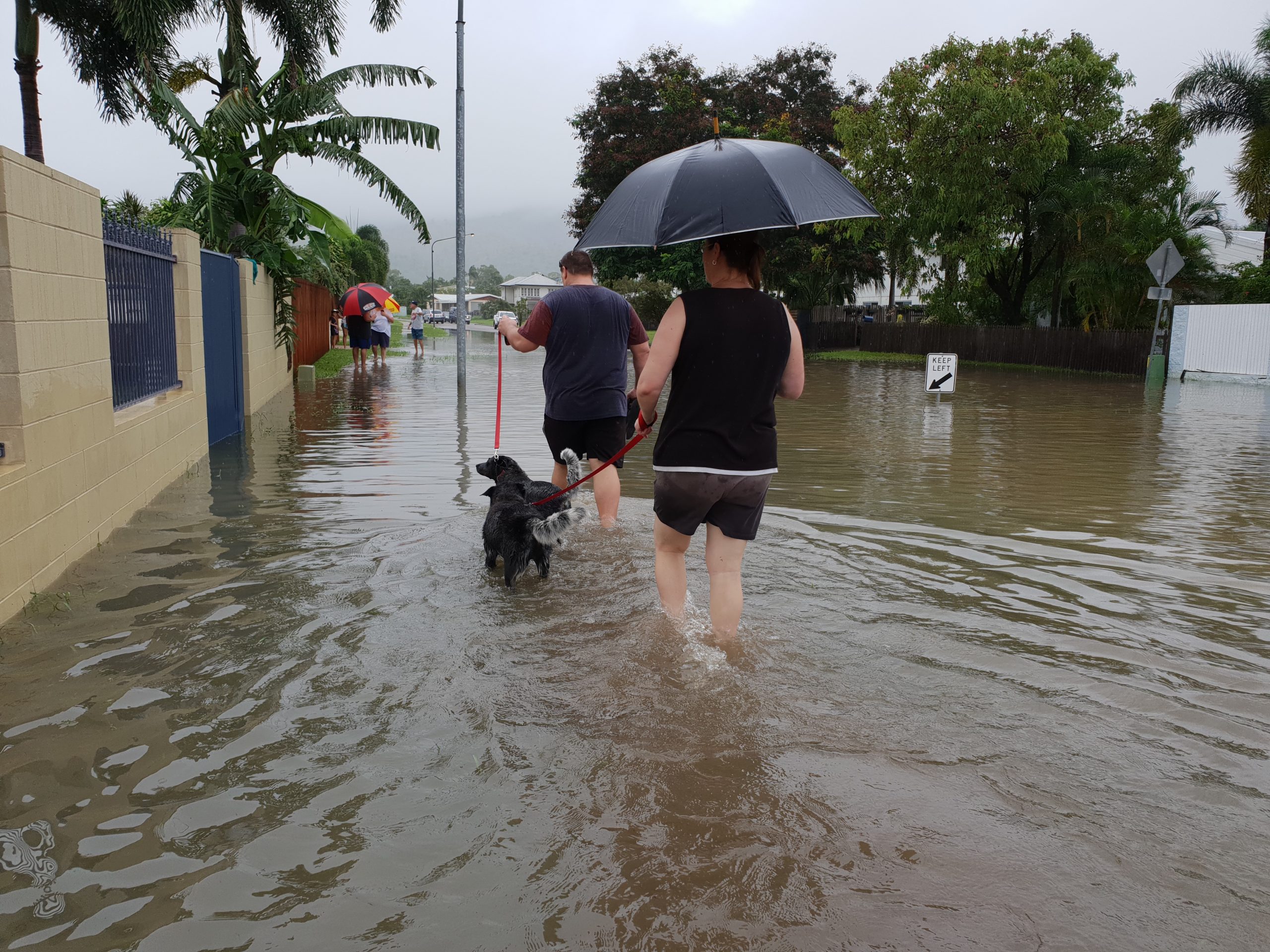 family walks in street after hurricane