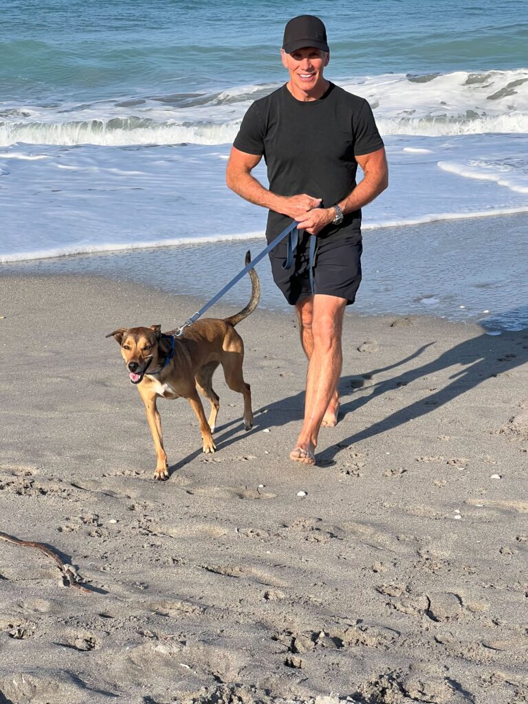 Dave and his dog, Sasha, strolling along a beach