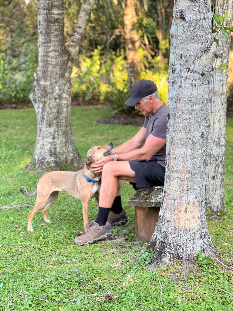 Dave sitting on a bench with his dog, Sasha